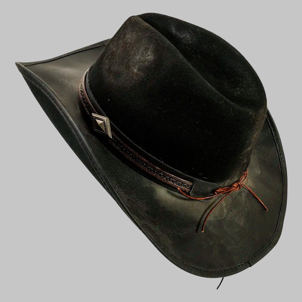 Black leather hat with a brown band and decorative element on a gray background